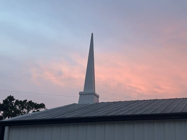 The steeple against a pink evening sky